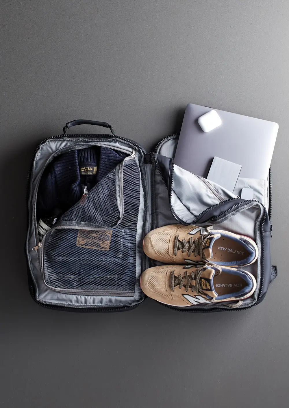 Geöffneter dunkelblauer Rucksack aus Textil von XD Design mit Gegenständen darin